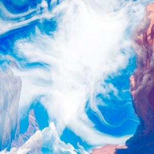 Abstract canyon landscape with swirling white clouds filling a bright blue sky, framed by layered sandstone cliffs in soft pinks and reds, creating a dynamic, dreamlike sense of motion and scale.