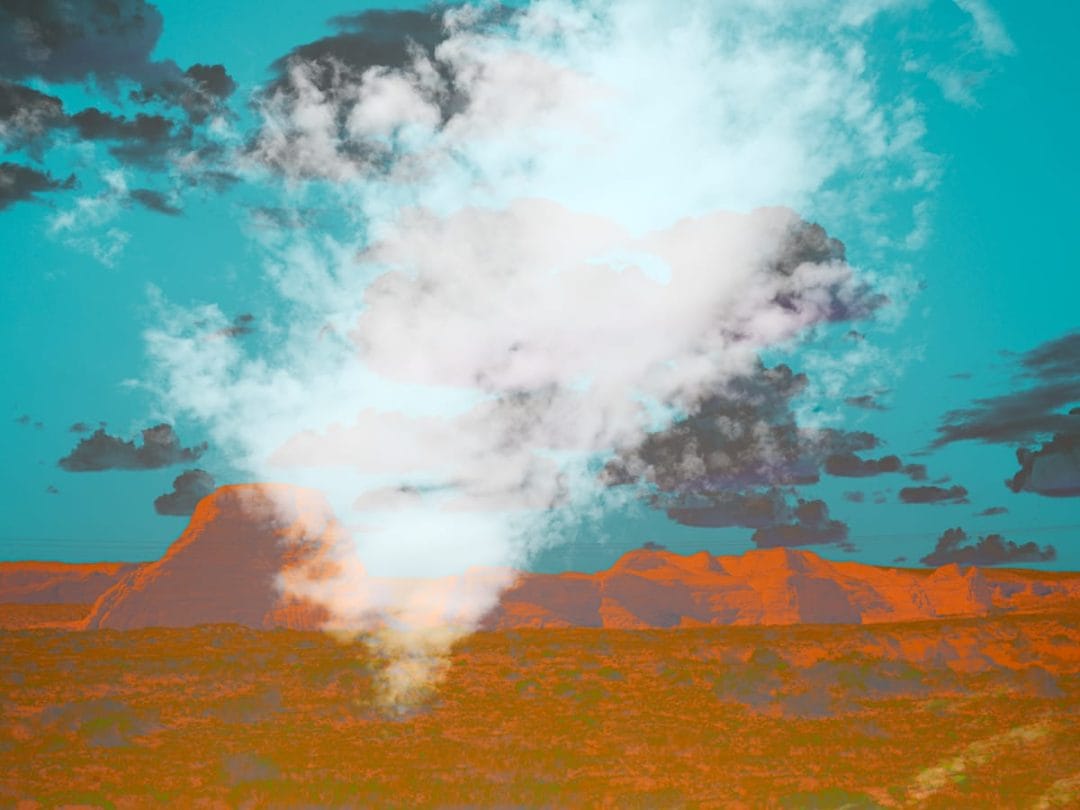 Abstract desert landscape with glowing orange mesas beneath a teal sky filled with layered clouds, featuring a luminous vertical plume of light and cloud at the center that creates a surreal, atmospheric effect.